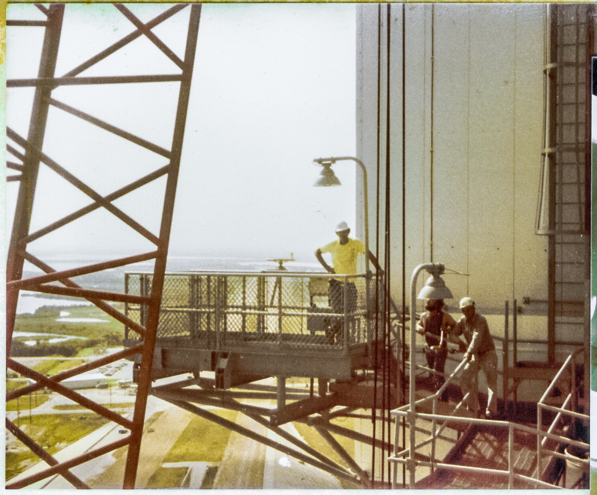 James MacLaren, Tommy Northcutt, and Carlton Taylor on the Left SRB Access Platform and its access catwalk, above the 200' level of the RSS at Launch Complex 39-B, Kennedy Space Center, Florida.